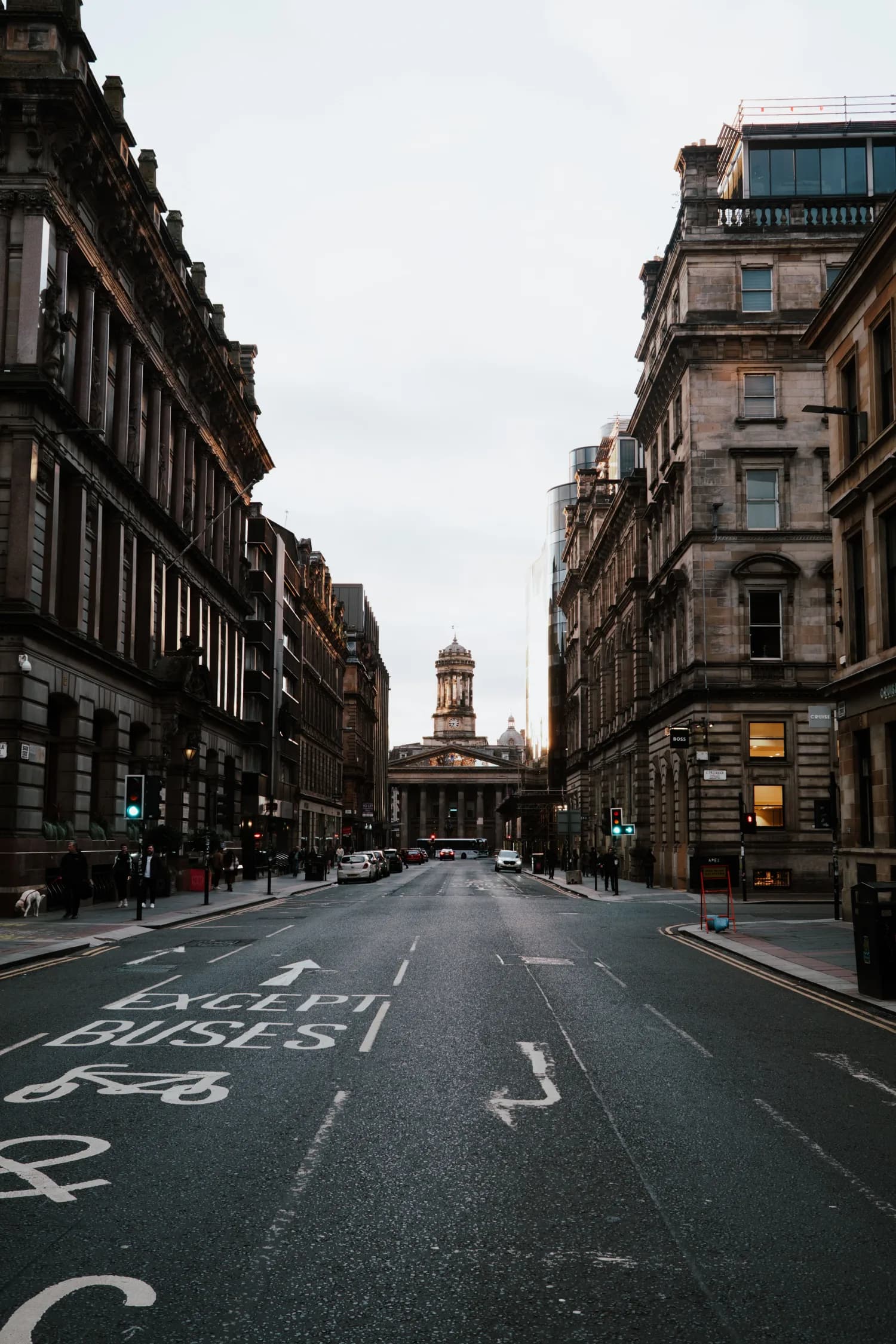 A broad Glasgow street framed by historic stone buildings
